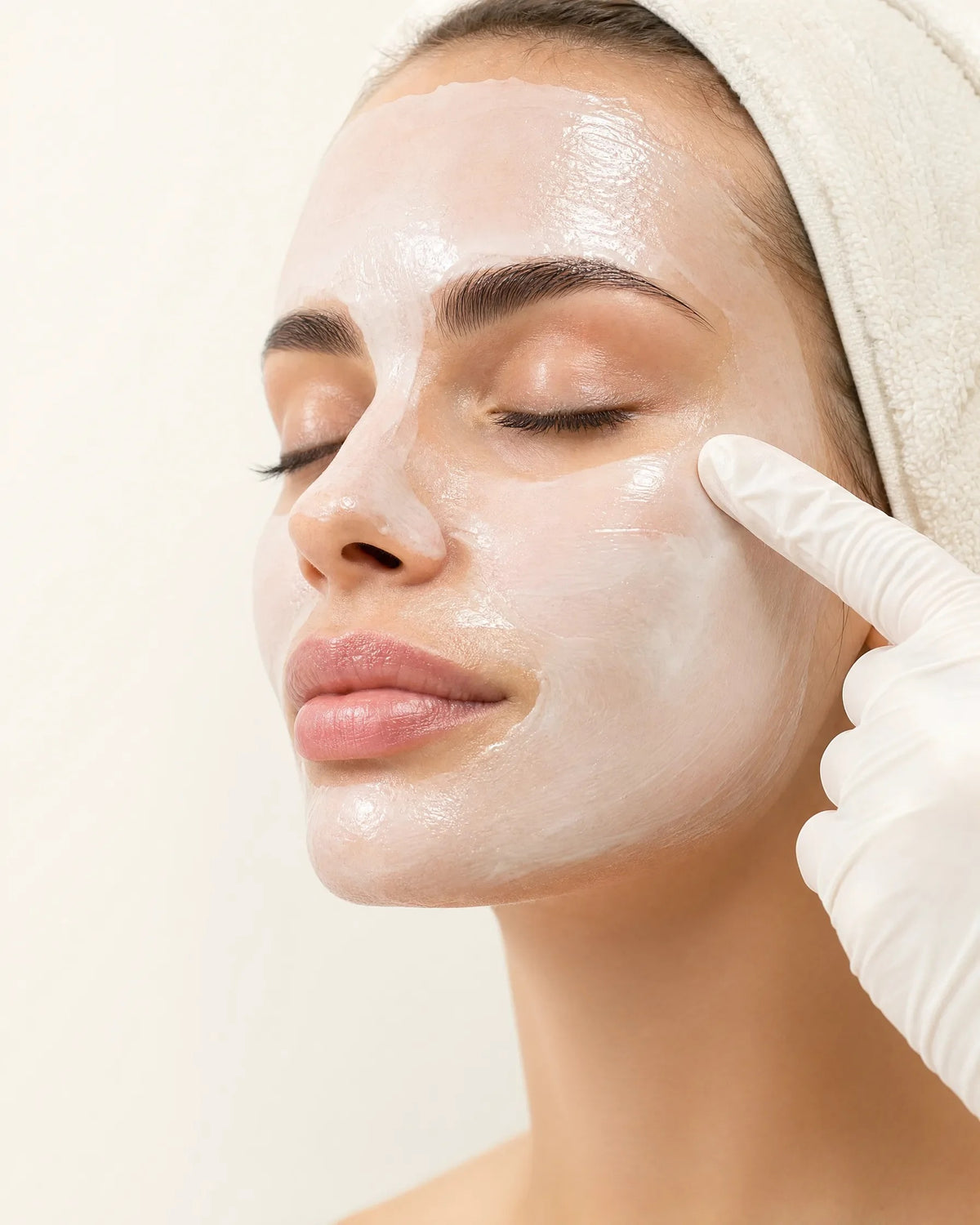 Cooling mask smoothed across the cheeks during a facial