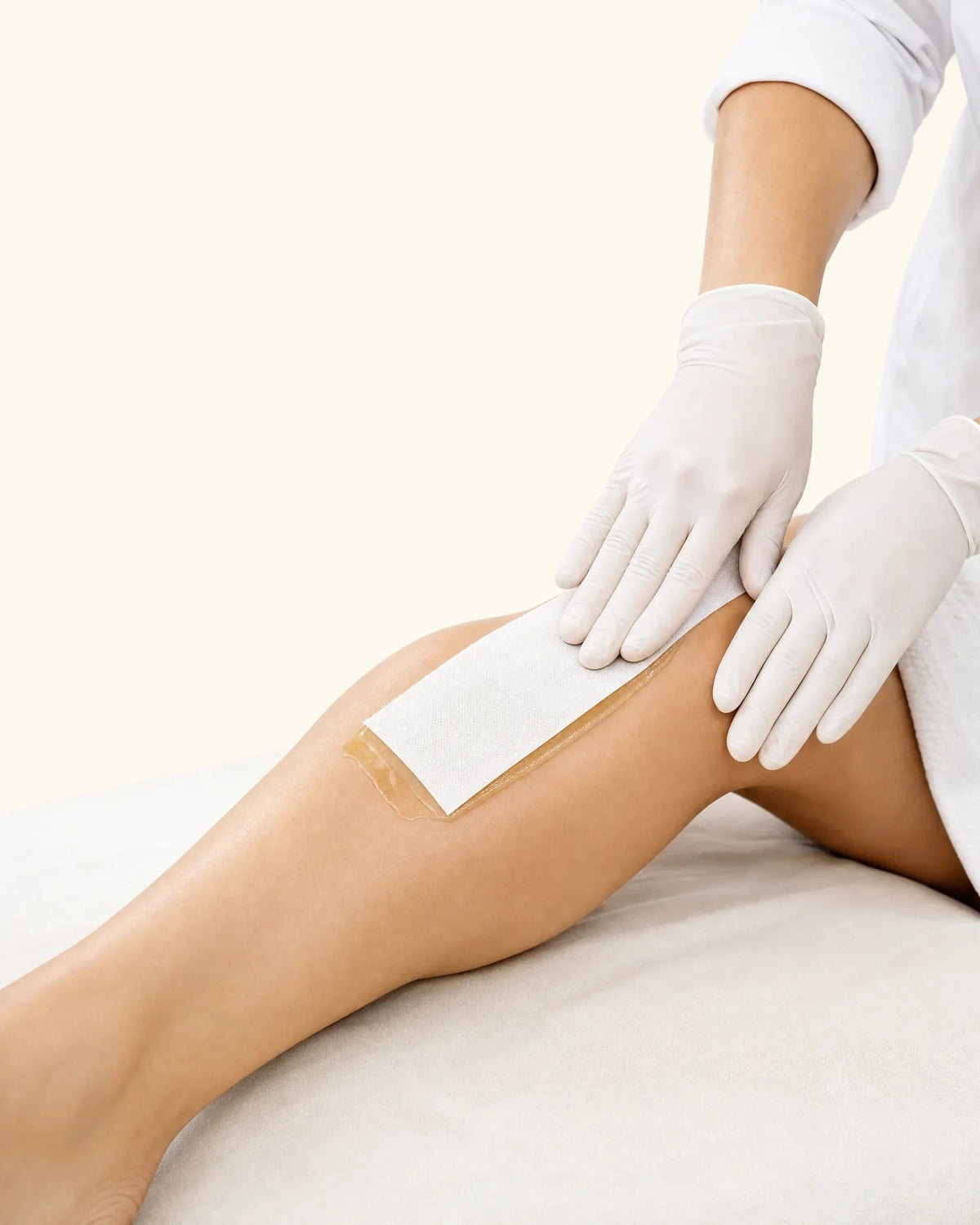 Wax strip smoothed over the lower leg during waxing
